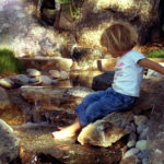 Girl playing in a Water Feature with Waterfall in Bozeman MT