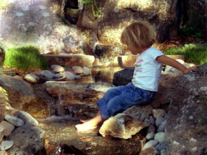 Girl playing in a Water Feature with Waterfall in Bozeman MT